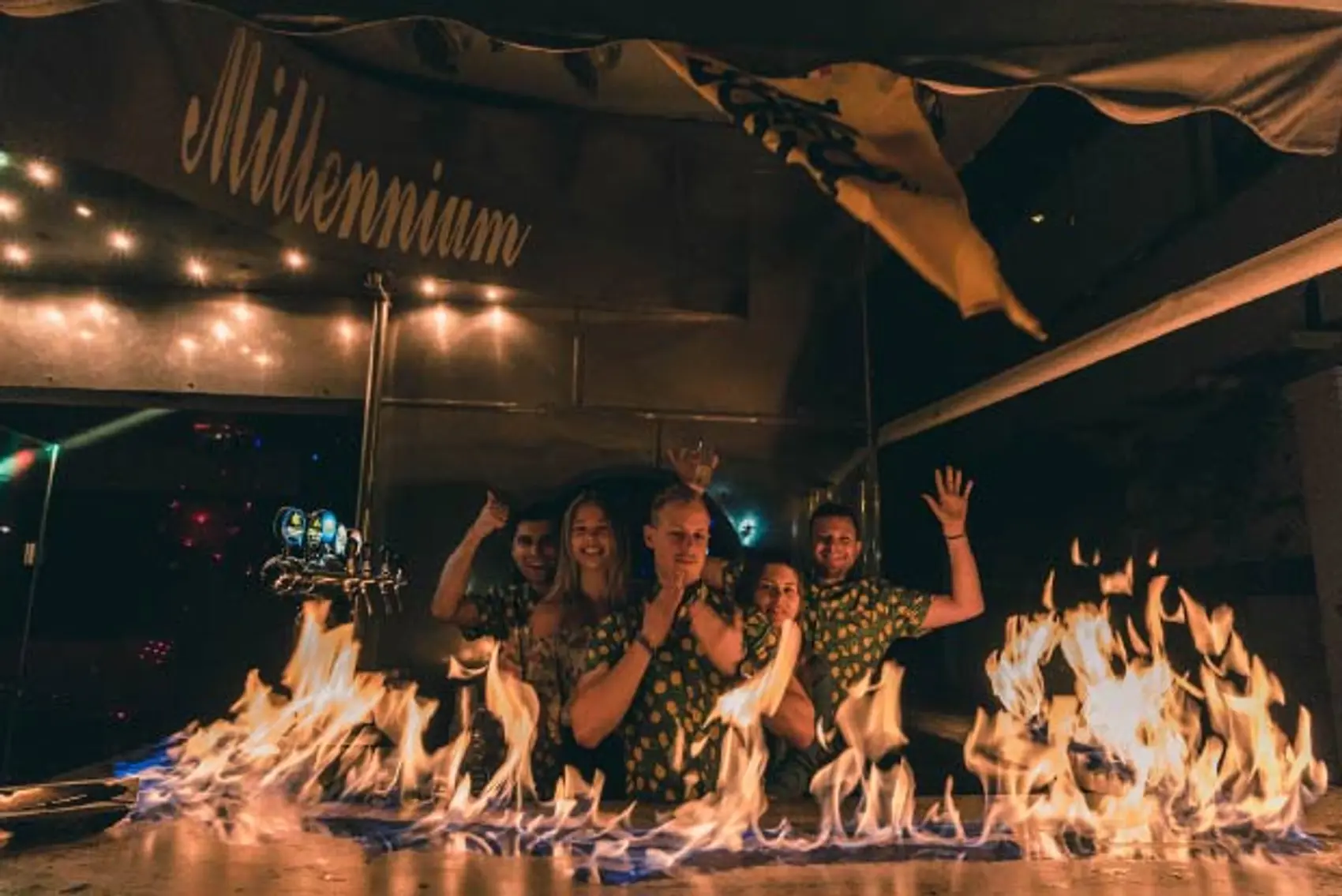 Photo of a bar on fire with people dancing behind it in Ermioni Greece.