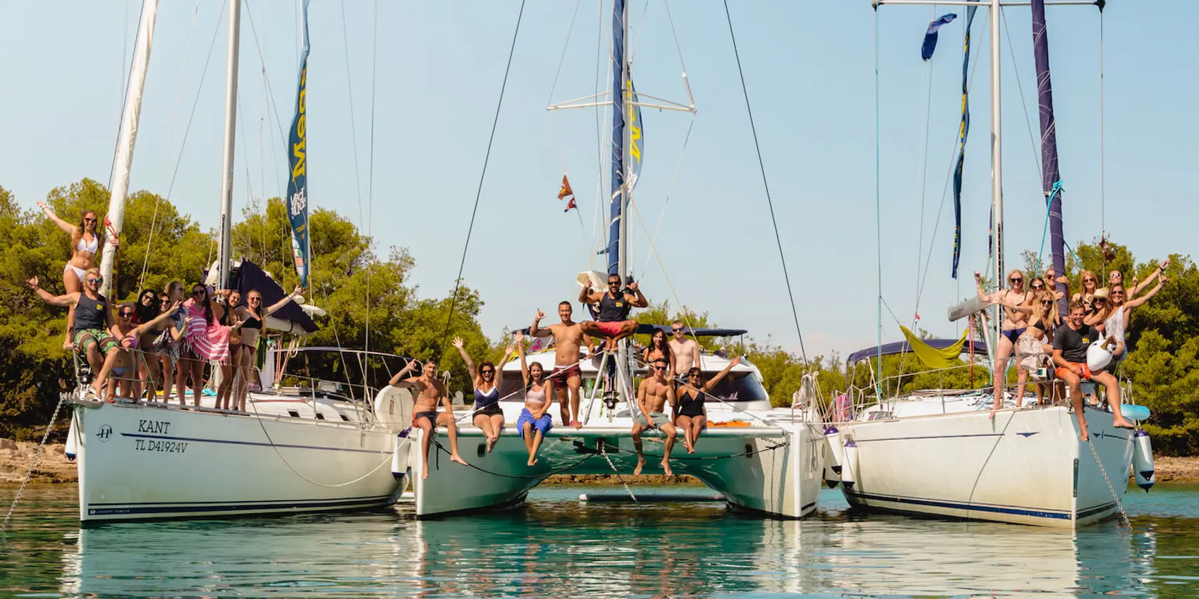 Photo of sailing yachts in a bay near Hvar Island as a flotilla with young guests aboard. Photo by Ryan Brown of LostBoyMemoirs.com